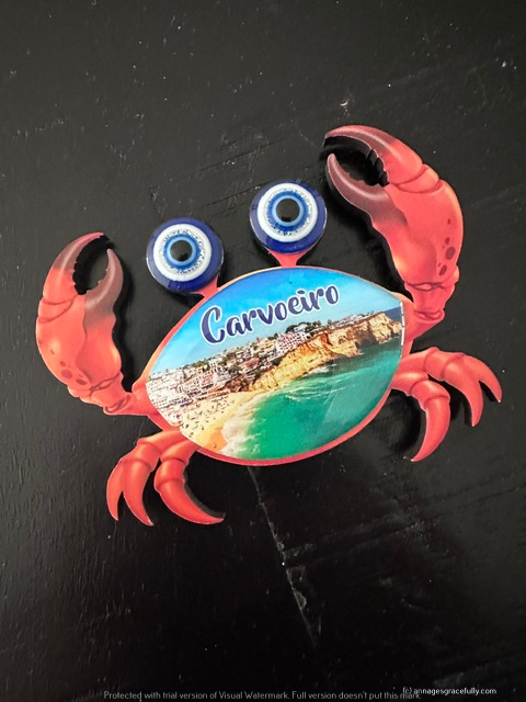 Een kleurrijke magneet in de vorm van een krab, met het opschrift 'Carvoeiro' en een afbeelding van de kustlijn.