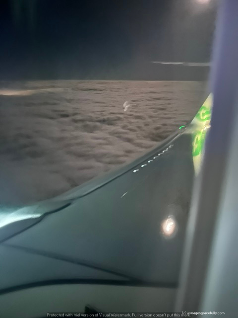 Uitzicht vanuit een vliegtuigraam op een wolkenbedekking tijdens de vlucht.