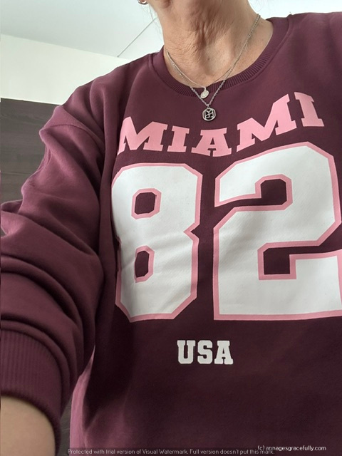 Detail van een persoon die een bordeauxrode sweatshirt draagt met de tekst 'MIAMI 82 USA'.