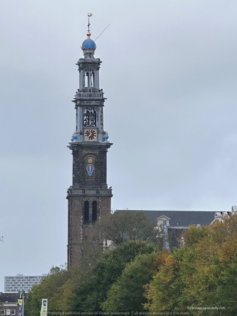 Uitzicht op de toren van een historisch gebouw, met een opvallende blauwe bol aan de top en een grote klok.